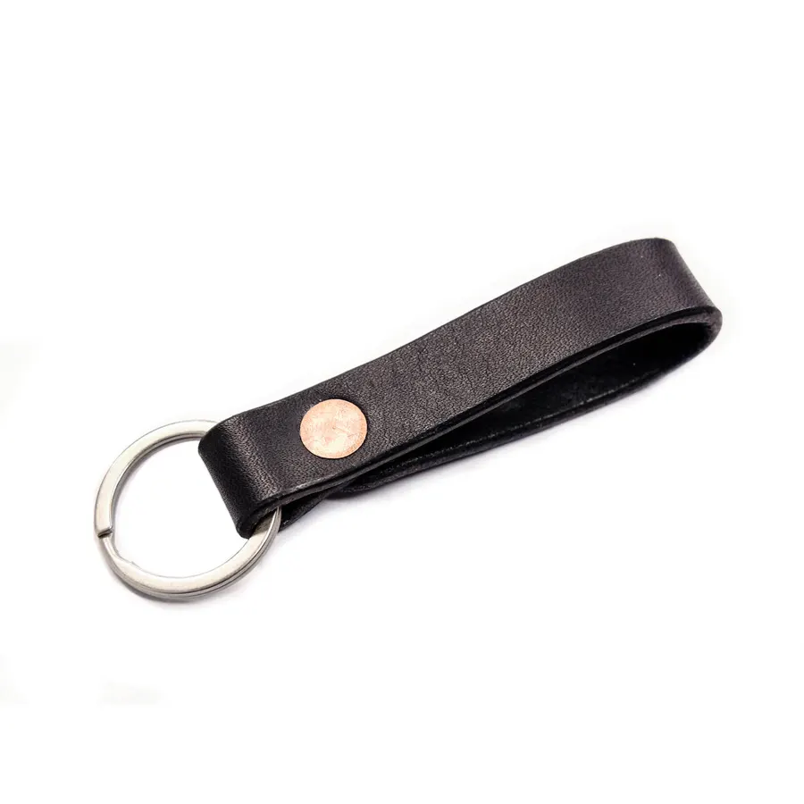 A black leather key loop with a copper rivet and a silver key ring, shown against a white background.