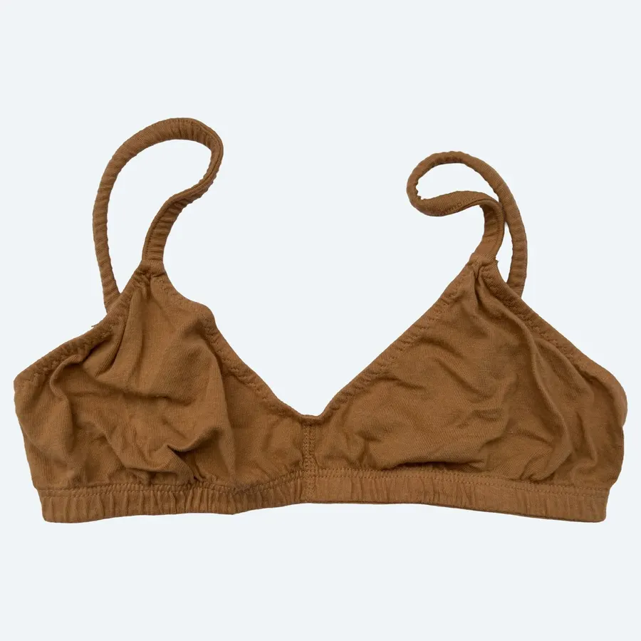 A tan organic cotton triangle bralette with thin straps, laid flat against a pale grey background.