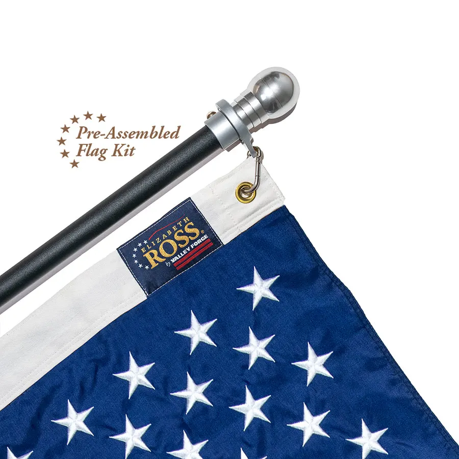 A close-up of a black aluminum flagpole with a silver ball finial holding an embroidered-star American flag with an Elizabeth Ross by Valley Forge label, against a white background.